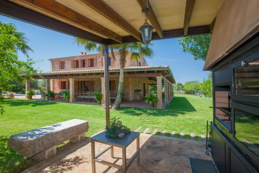 A covered patio overlooks a lawn and a two-story house.