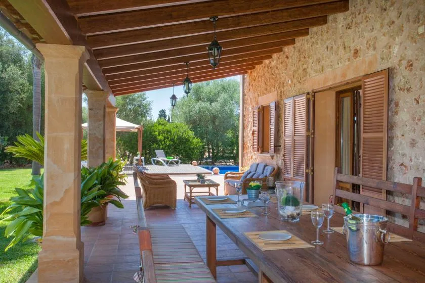 A covered outdoor dining area opens onto a patio with a swimming pool.