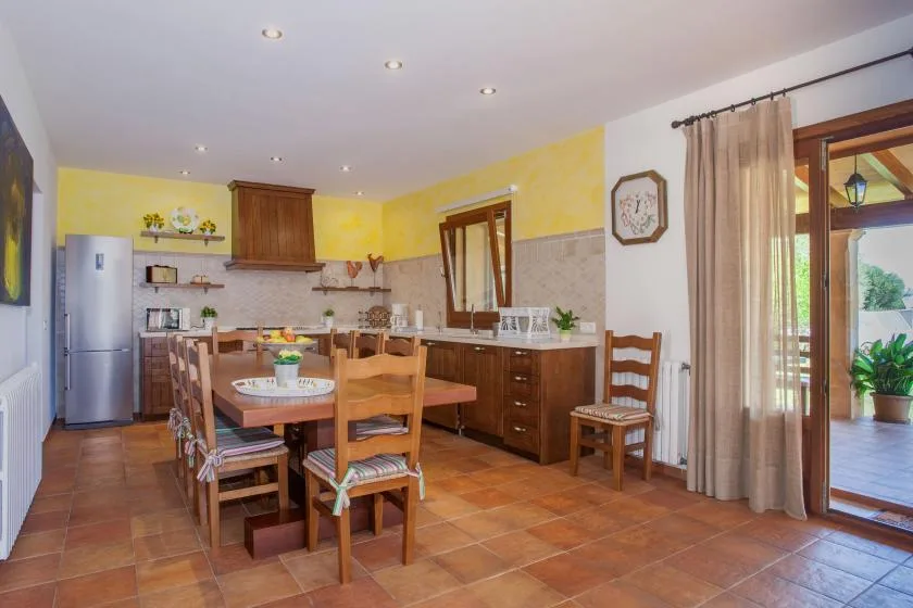 A bright kitchen and dining area with wooden cabinets and a dining table.