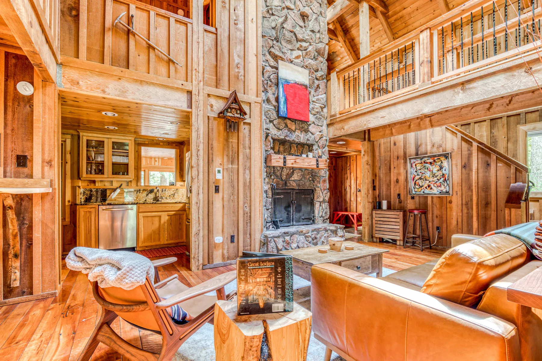 A wood-paneled living room with a stone fireplace and seating.