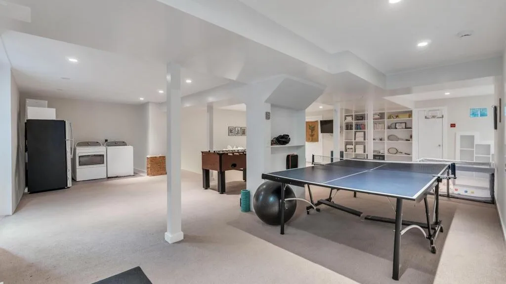Una sala de juegos en el sótano con una mesa de ping-pong y futbolín.