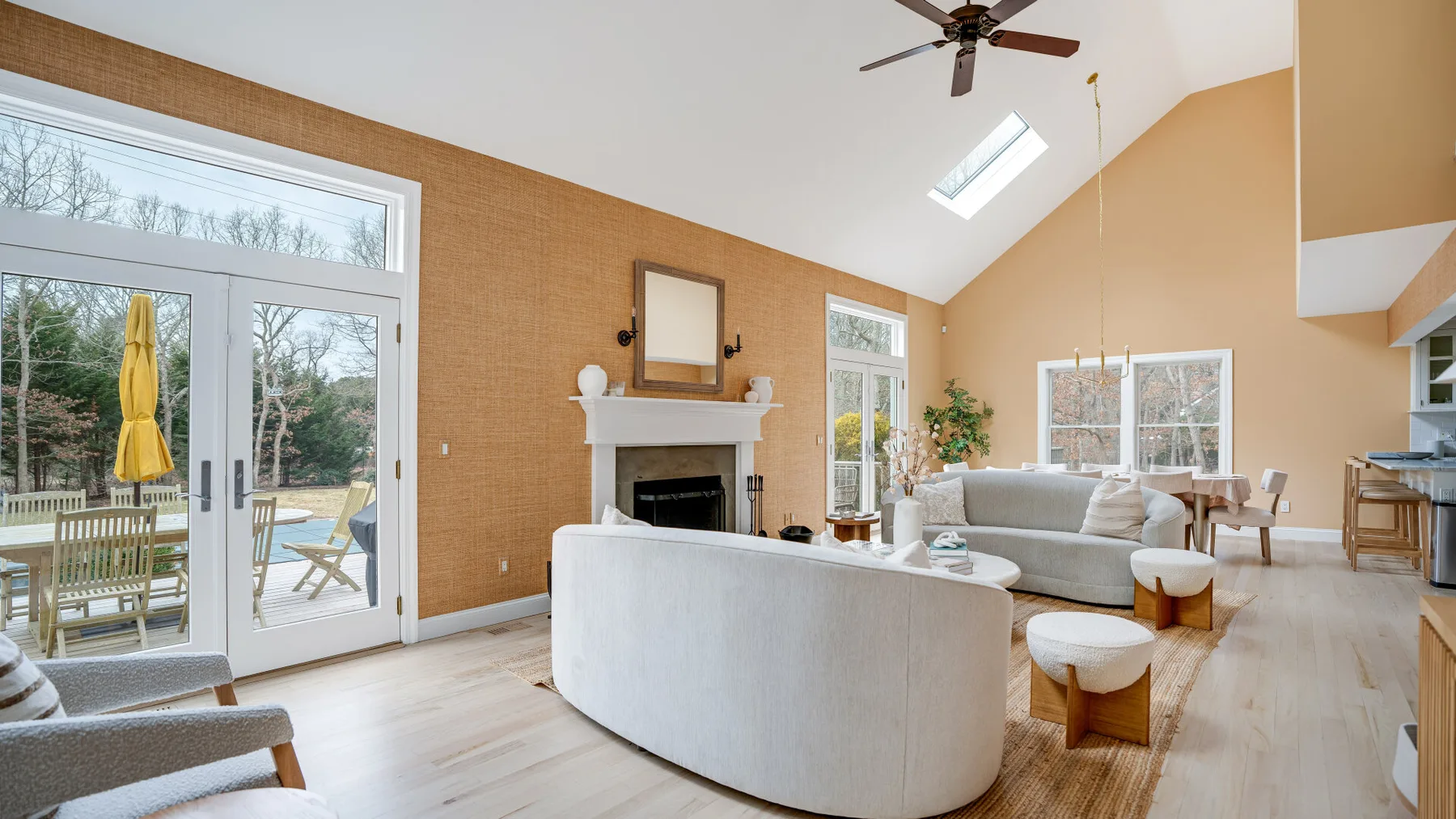 Una sala luminosa con asientos curvos, una chimenea y grandes ventanas.
