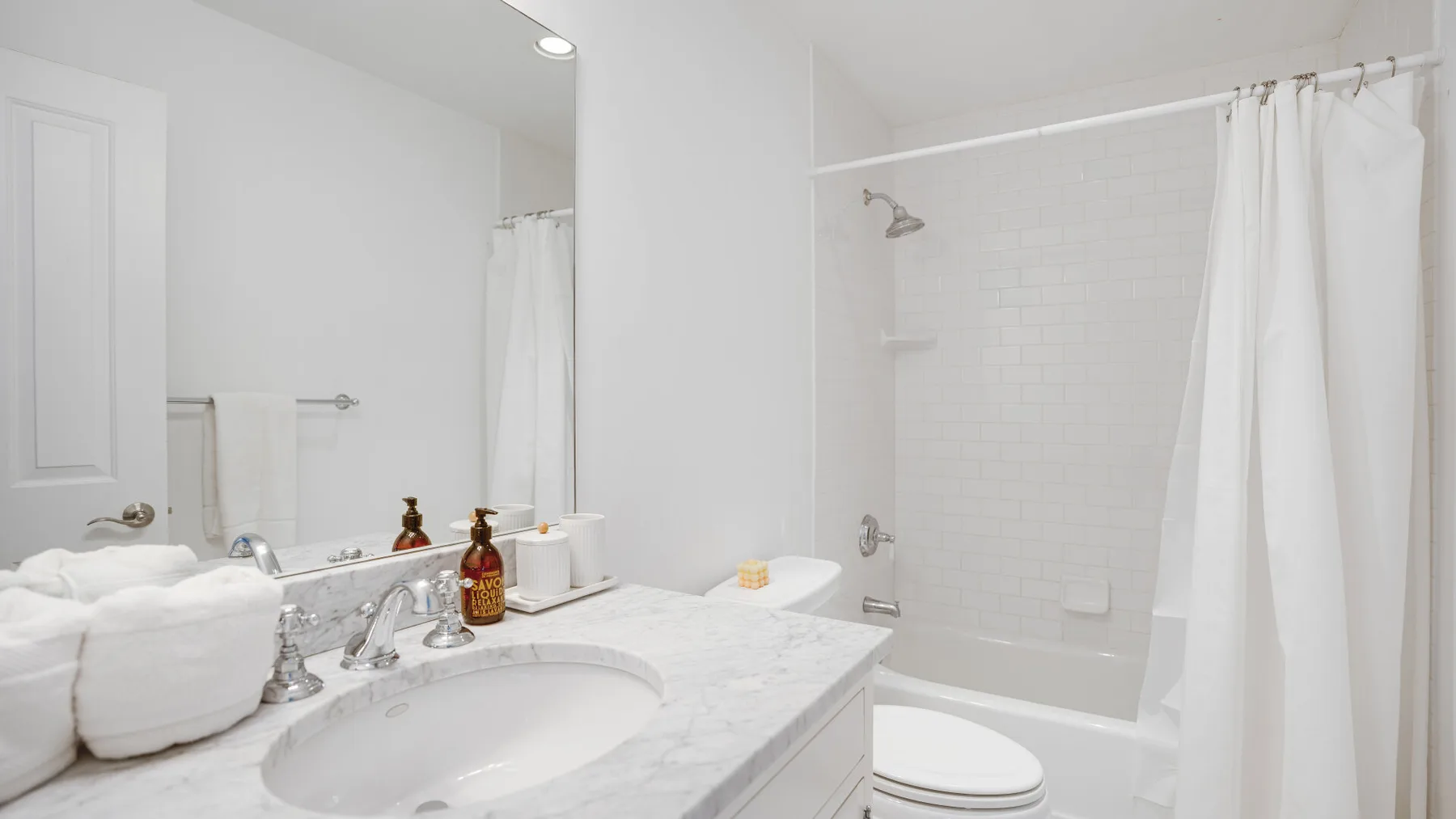 Un baño luminoso con lavabo, encimera y cortina de ducha.