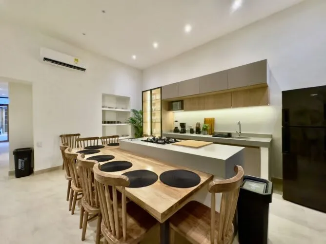 Una cocina moderna con una isla larga y asientos de madera.