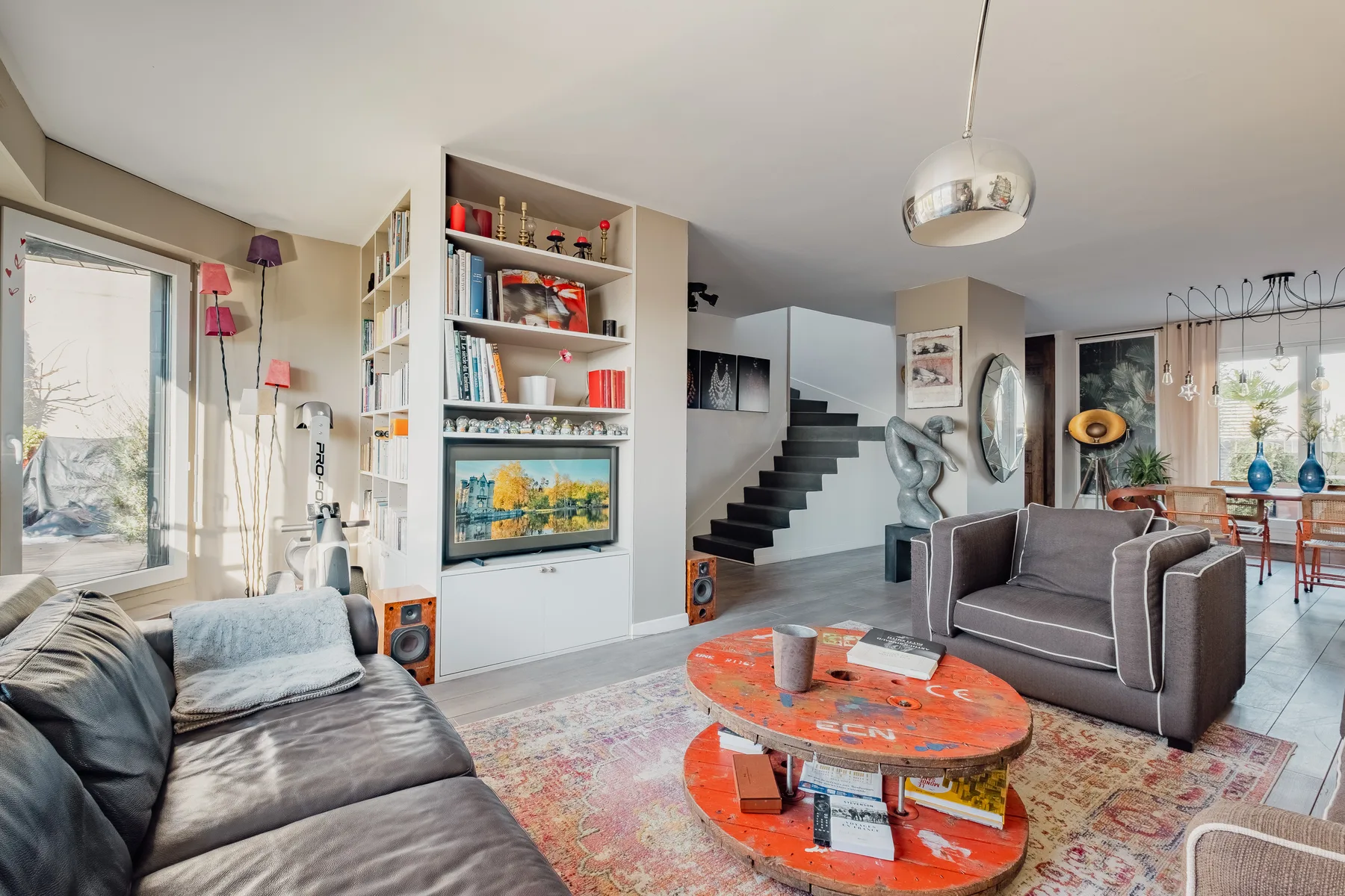 A living room with seating, a round coffee table, and bookshelves.