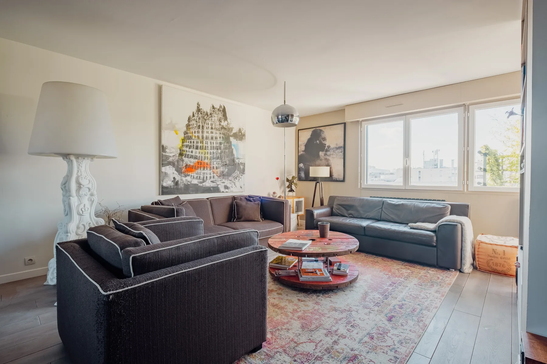 A bright living room with seating around a low round coffee table.