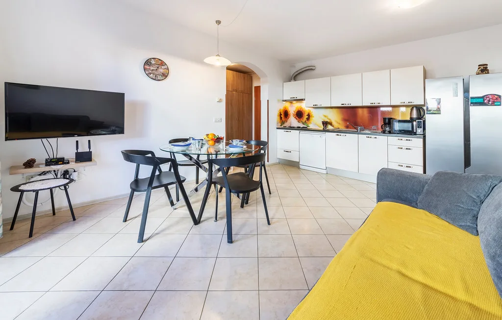 Una zona abierta de estar y comedor con cocina y asientos cubiertos de amarillo.