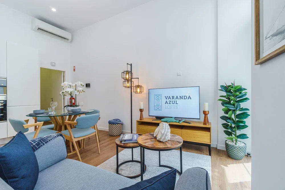 Una luminosa sala de estar y comedor con asientos, una mesa de comedor y un televisor.