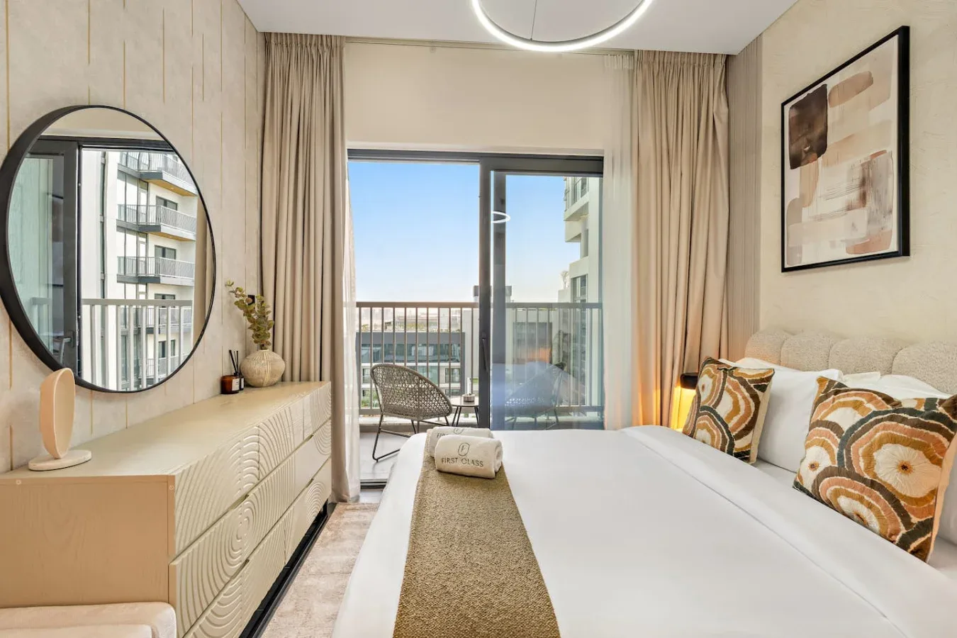 A bright bedroom with a large bed and glass doors opening onto a balcony.
