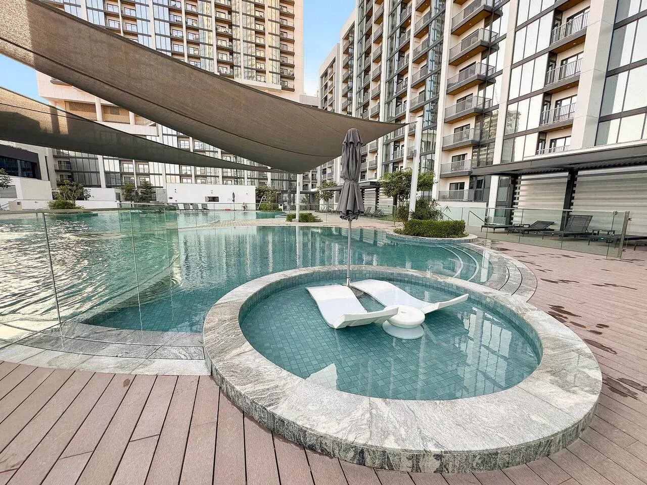 An outdoor swimming pool with a small circular shallow pool in front.