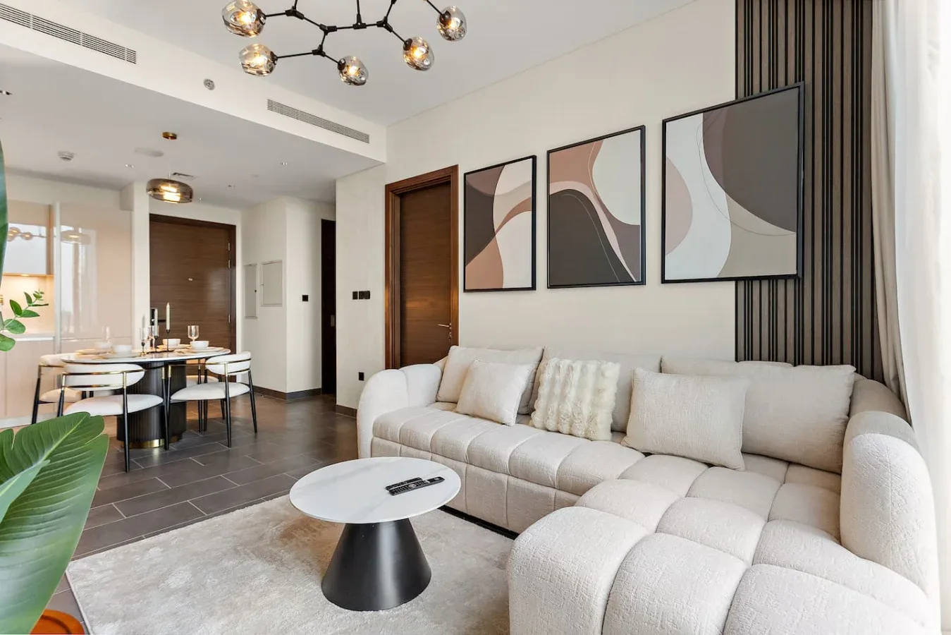 A living room with a sectional sofa, coffee table, and abstract wall art.