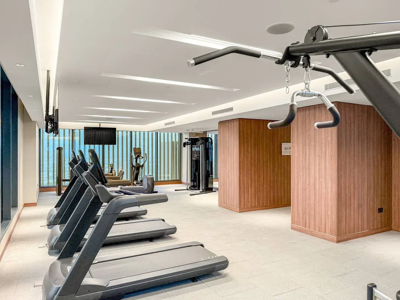 A gym with treadmills and exercise equipment in a bright room.