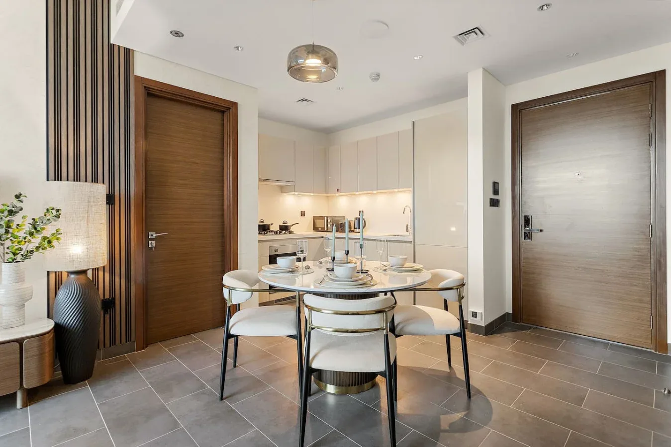 A dining area with a set table and a compact kitchen in the background.