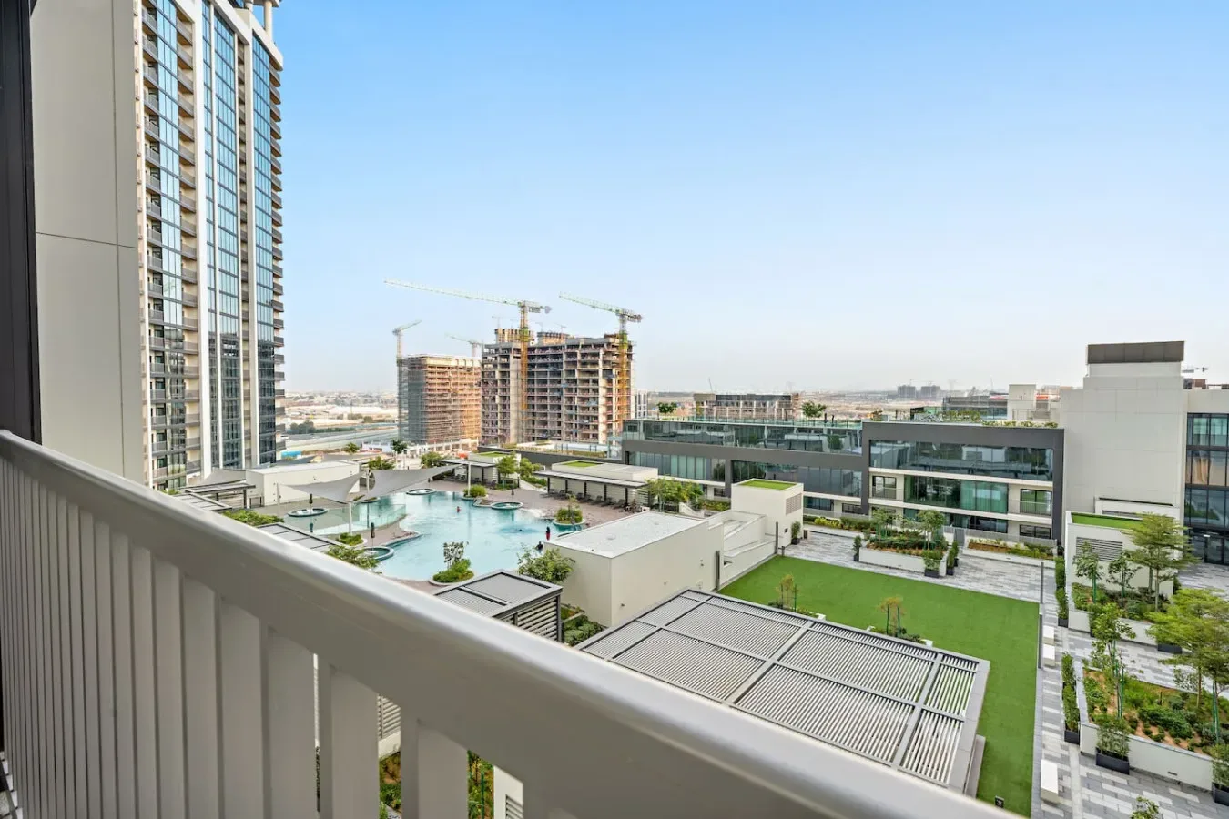 A balcony overlooks a landscaped courtyard and surrounding buildings.