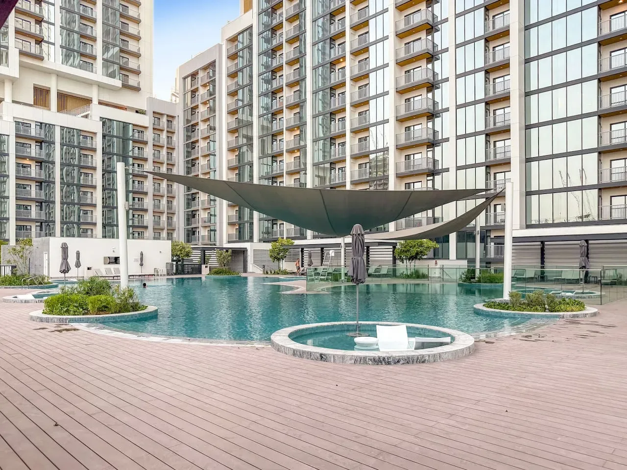 A courtyard swimming pool sits among modern apartment buildings.