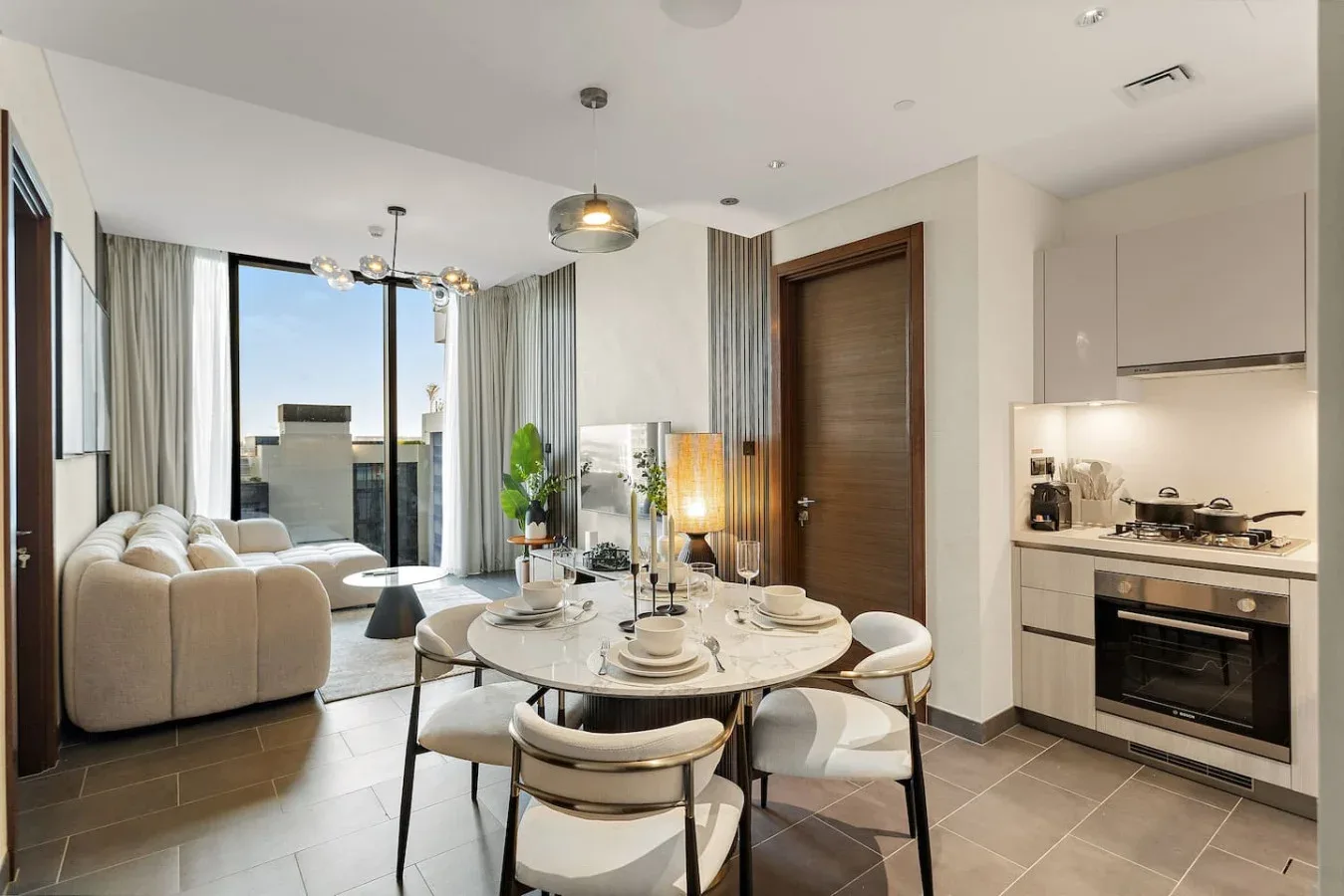 An open-plan living and dining area with a round table beside the kitchen.
