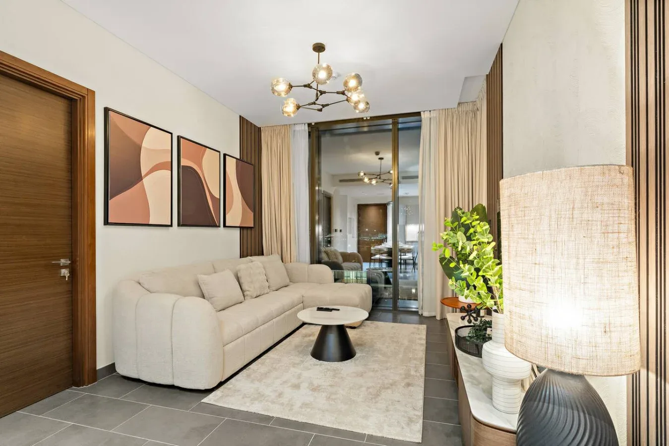 A living room with a light-colored sofa, coffee table, and large window.
