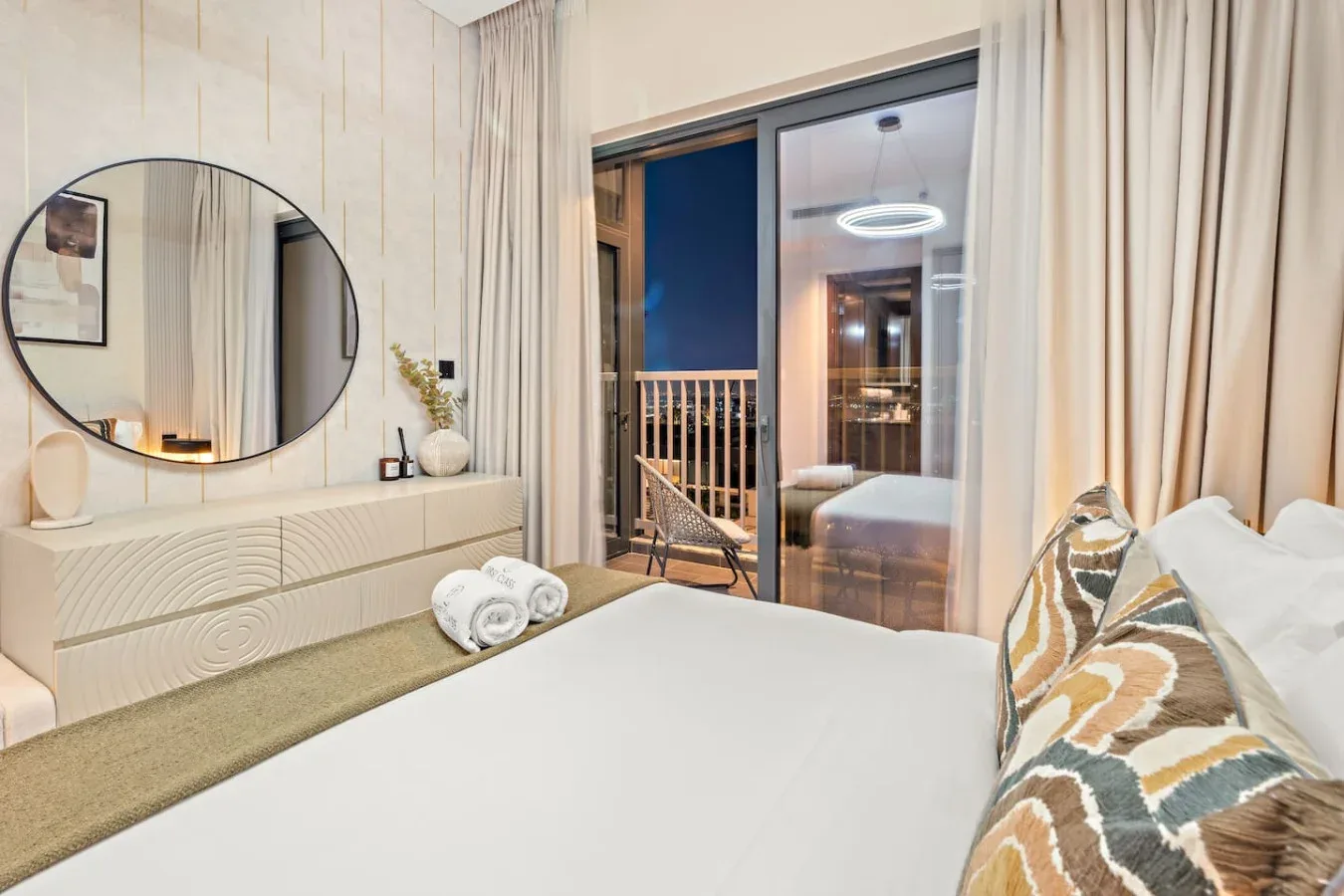 A bedroom with a large bed and glass doors opening onto a balcony.