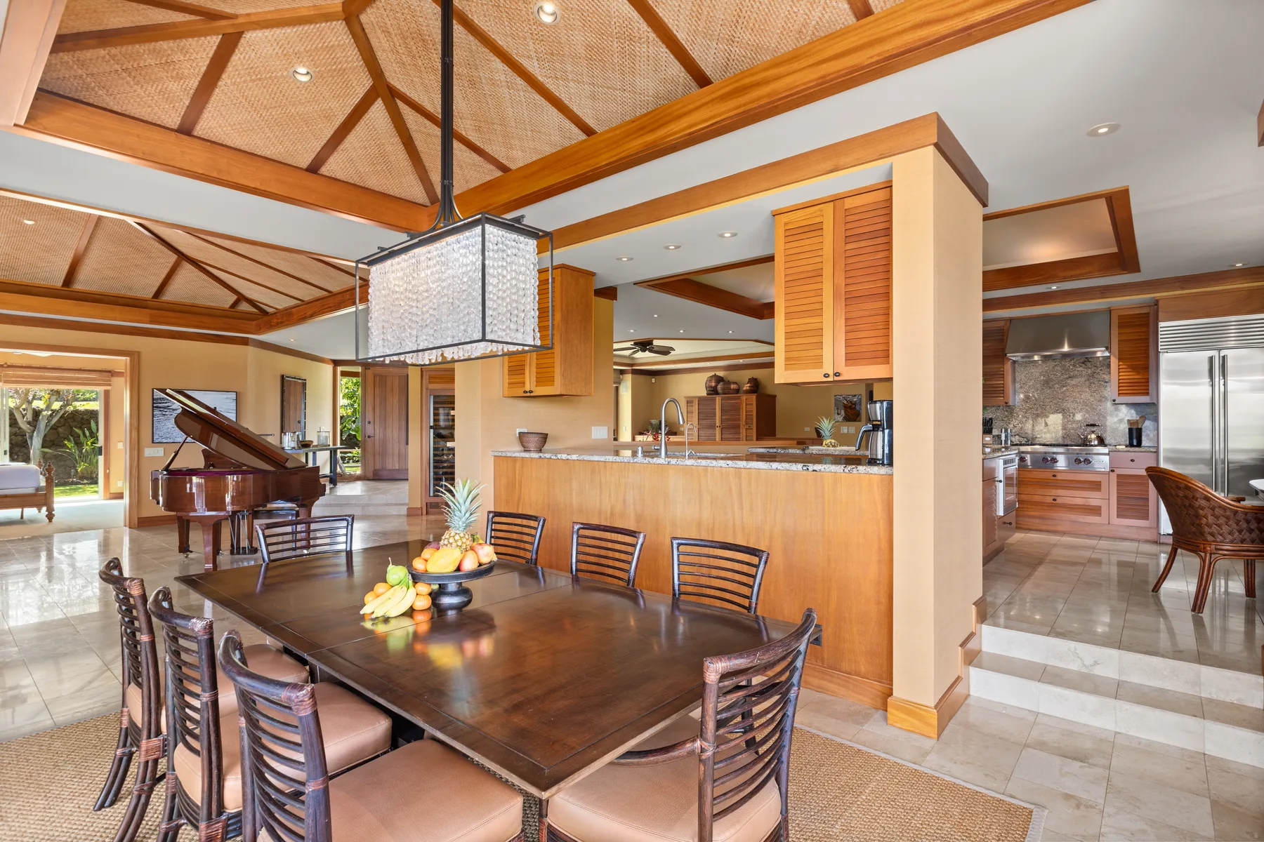 A dining area with a wooden table beside an open kitchen.