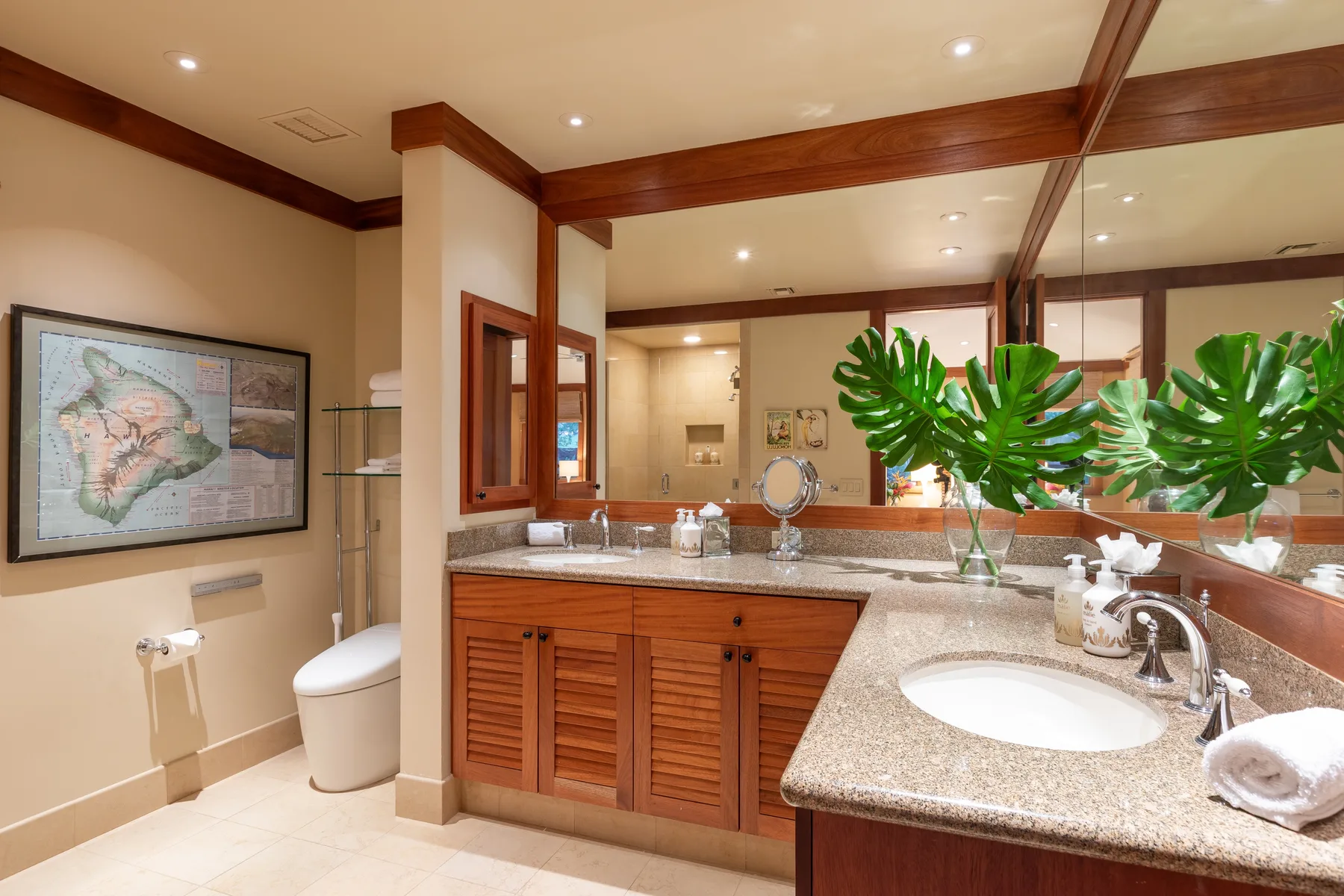 A bathroom vanity with a large mirror, sink, and potted greenery.