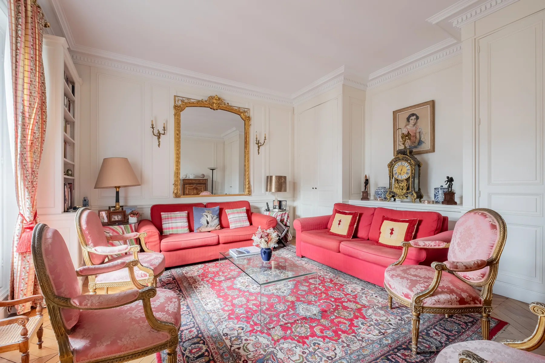 Una sala luminosa con asientos rojos dispuestos alrededor de una mesa de centro de vidrio.
