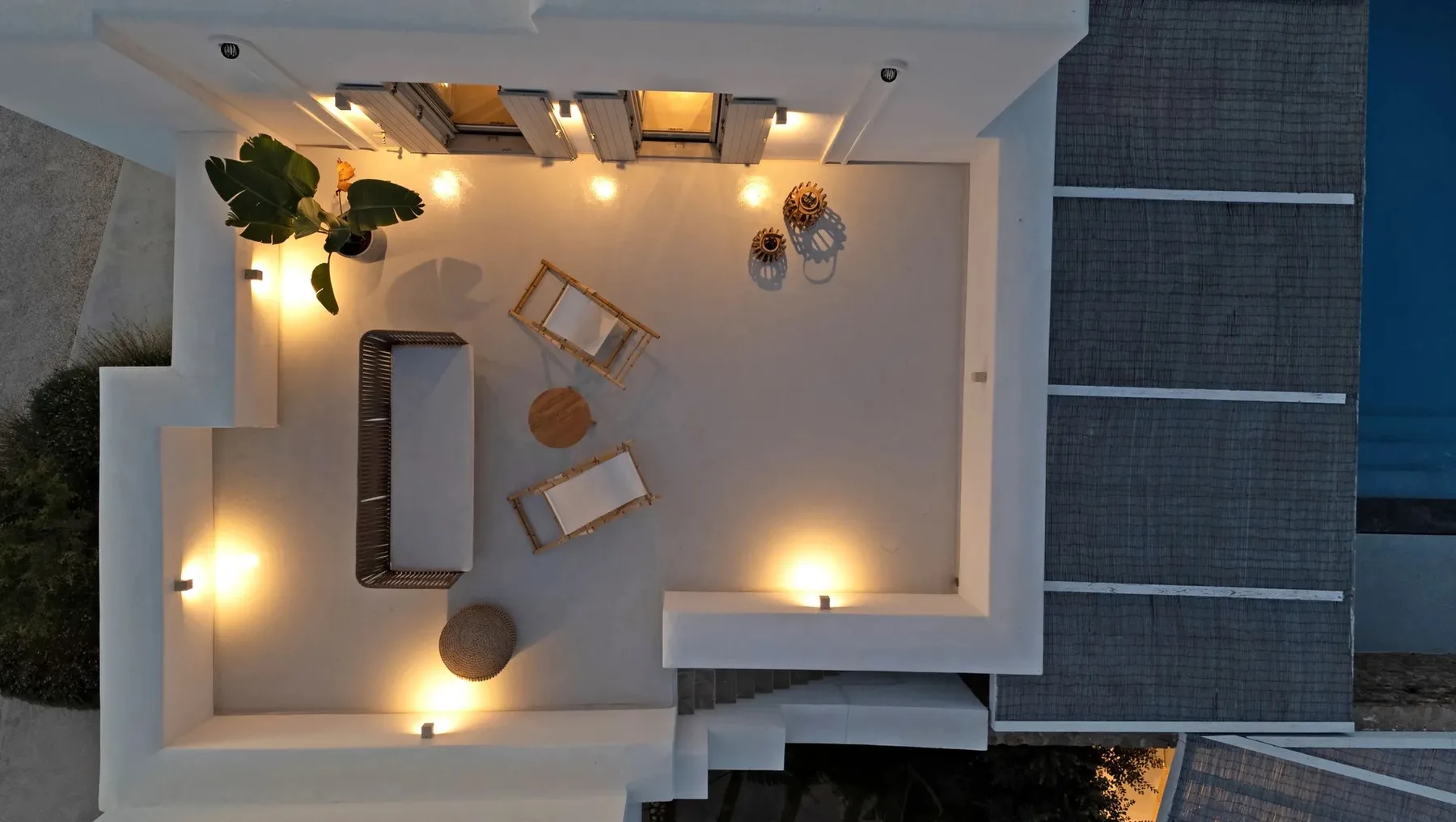 An elevated view of a rooftop lounge with seating and warm lighting.