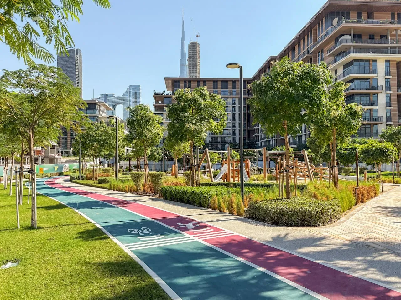 Un patio ajardinado al aire libre con un sendero colorido y juegos infantiles.