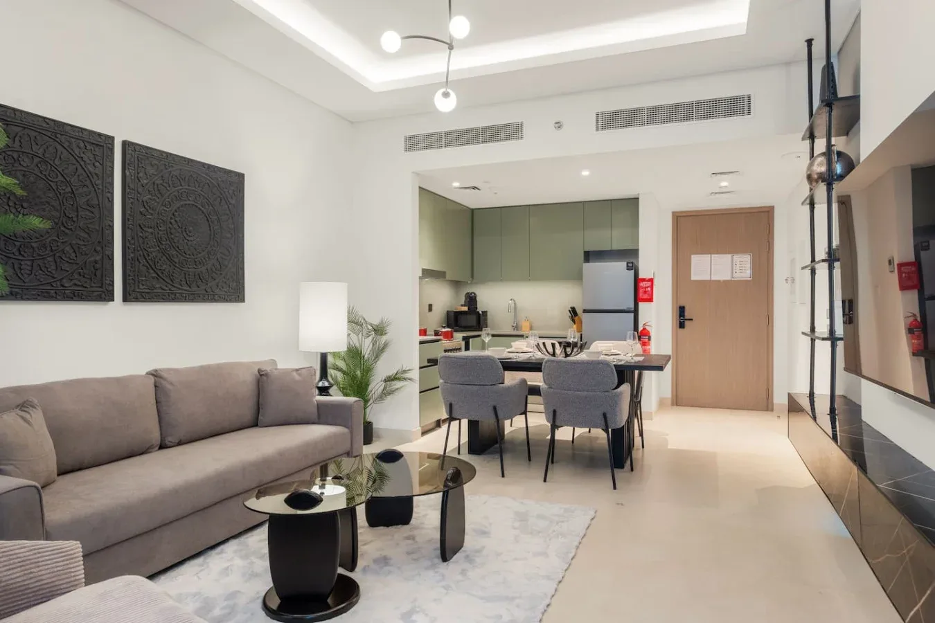 Una sala de estar moderna se conecta con una cocina, con asientos y una mesa de comedor.