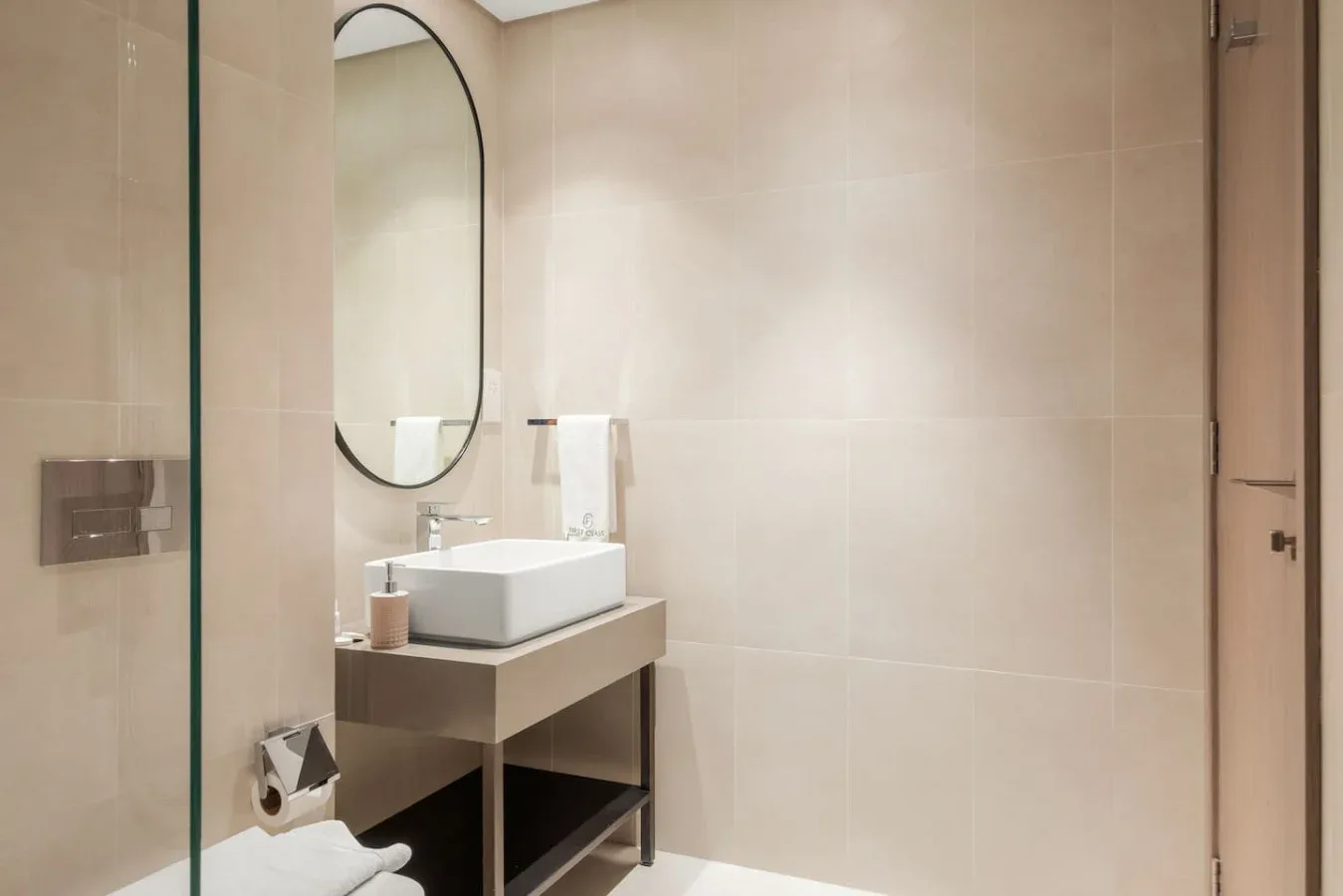 Un lavabo de baño con una pila sobrepuesta y un espejo ovalado.