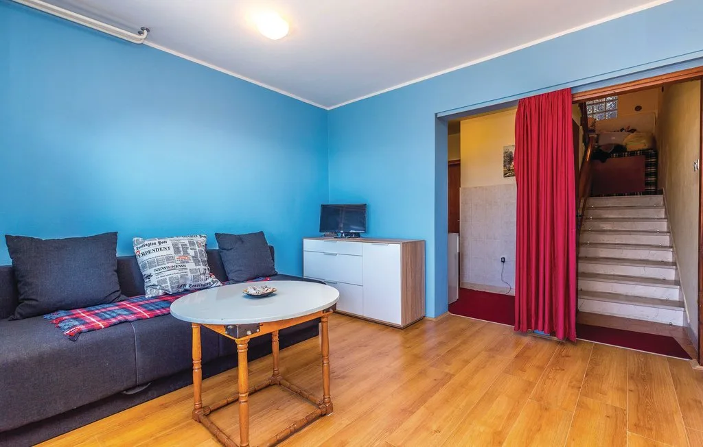 A living room with blue walls, seating, and a small television.