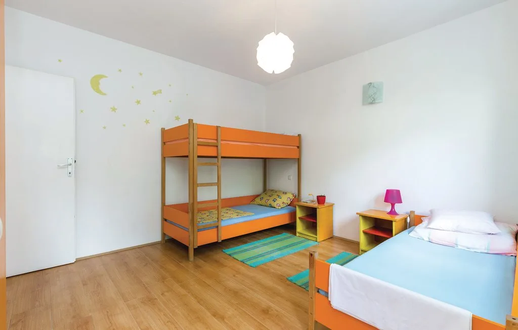 A bedroom with bunk beds, a single bed, and colorful wall decorations.