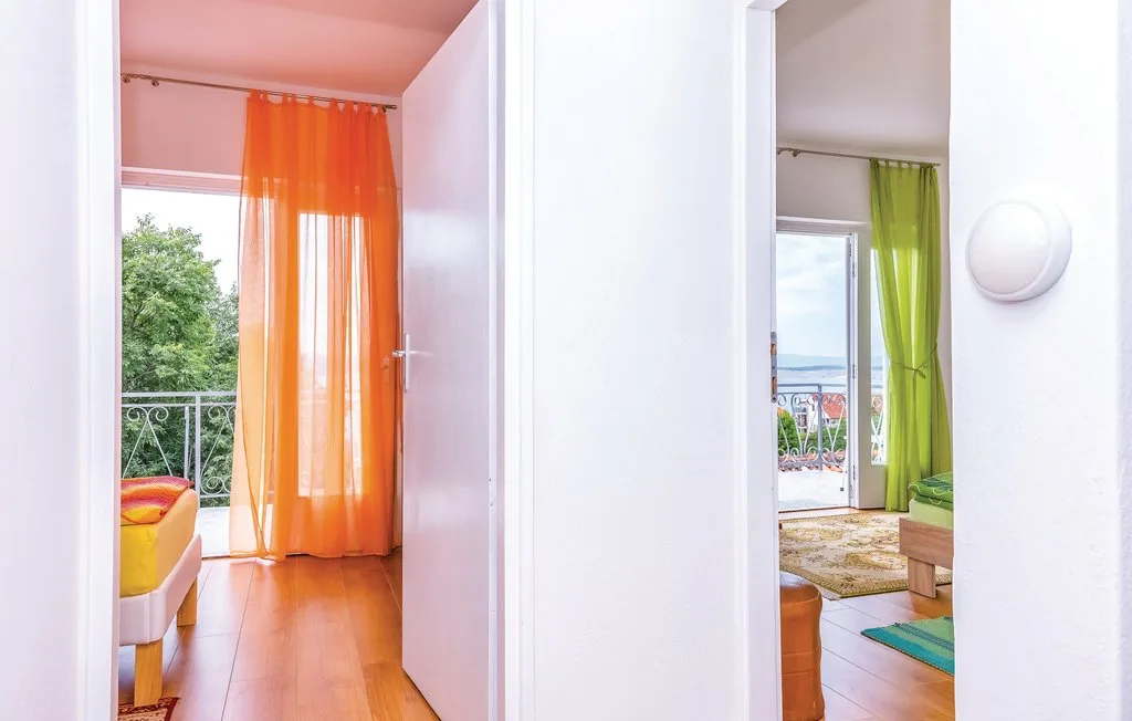 Two open doorways show bright rooms with colorful curtains and balcony views.