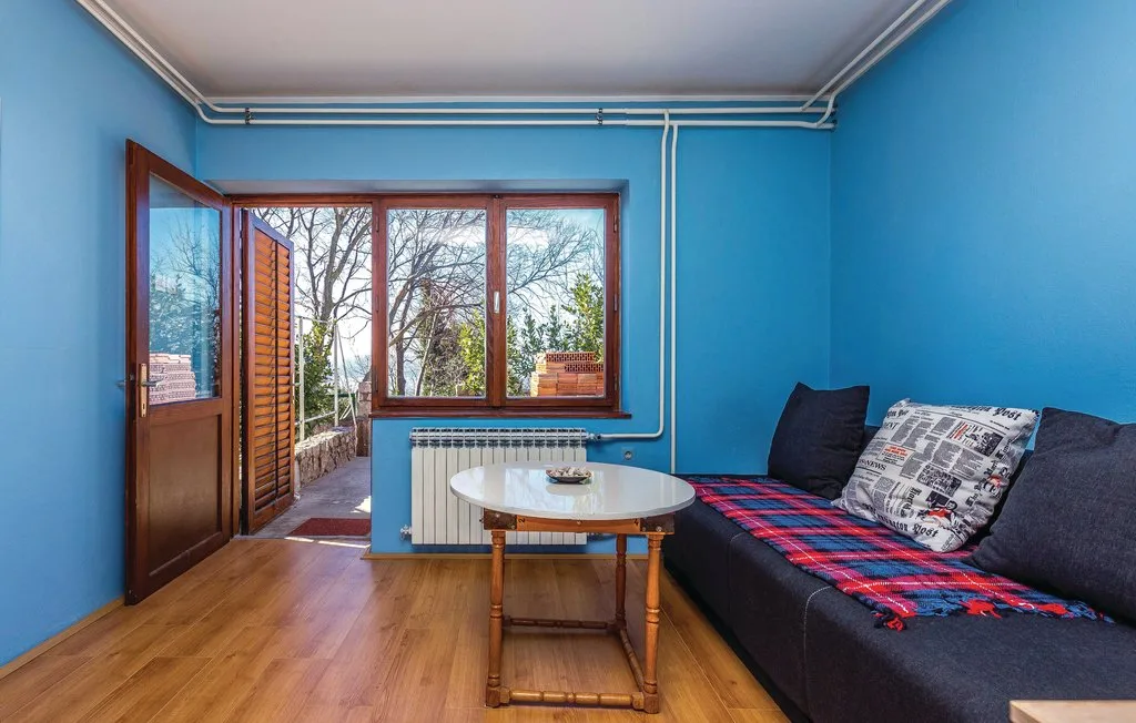 A blue-walled living room with a dark sofa and a small table.