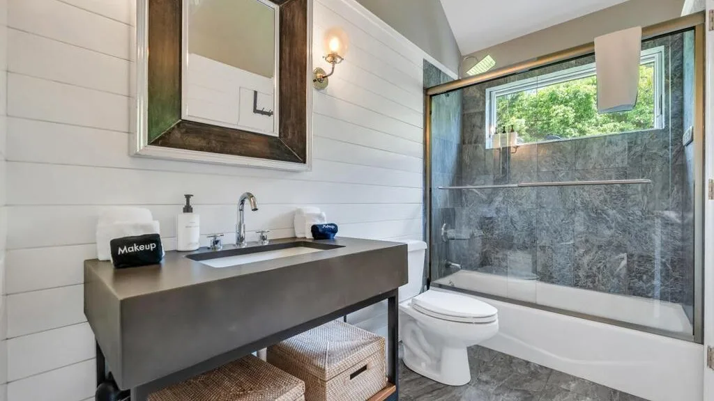 A bathroom with a wide sink, toilet, and glass-enclosed shower.