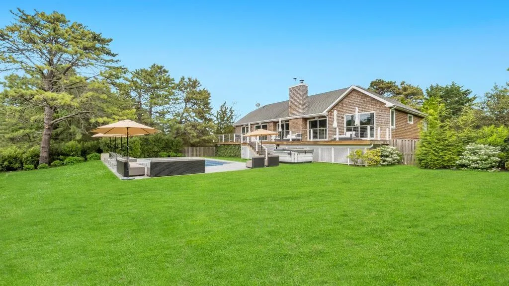 A house and swimming pool sit beside a broad green lawn.