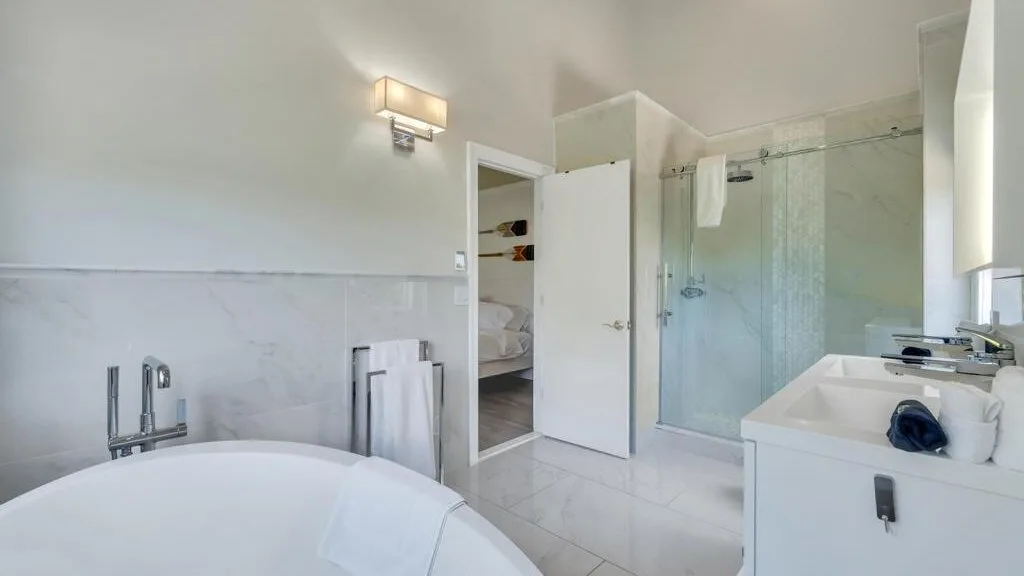 A bright bathroom with a glass shower and a white vanity.