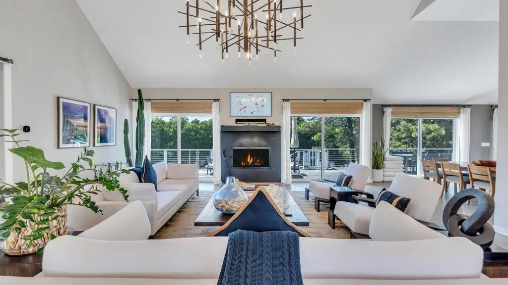 A bright living room with seating arranged around a fireplace and coffee table.