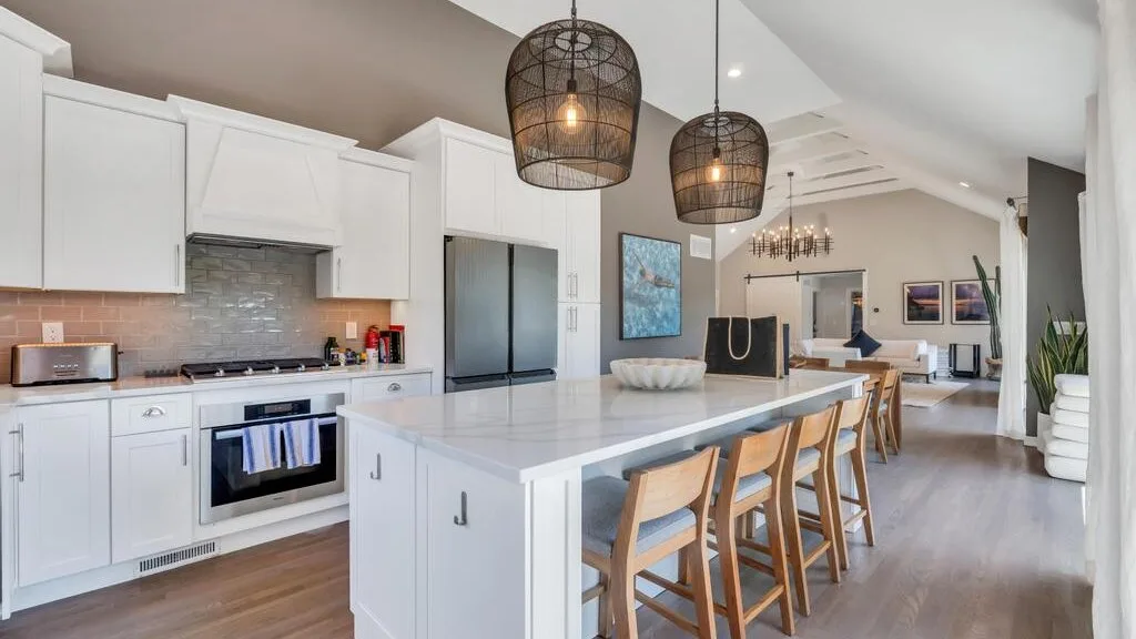 A bright open-plan kitchen and dining area with a large island and bar seating.
