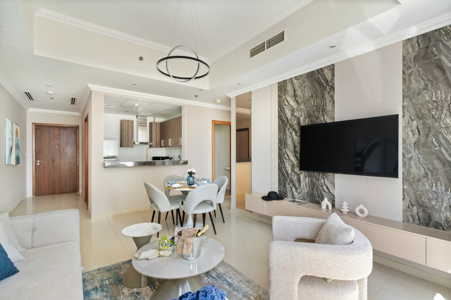 Una sala luminosa con una mesa de comedor y un televisor montado en la pared.