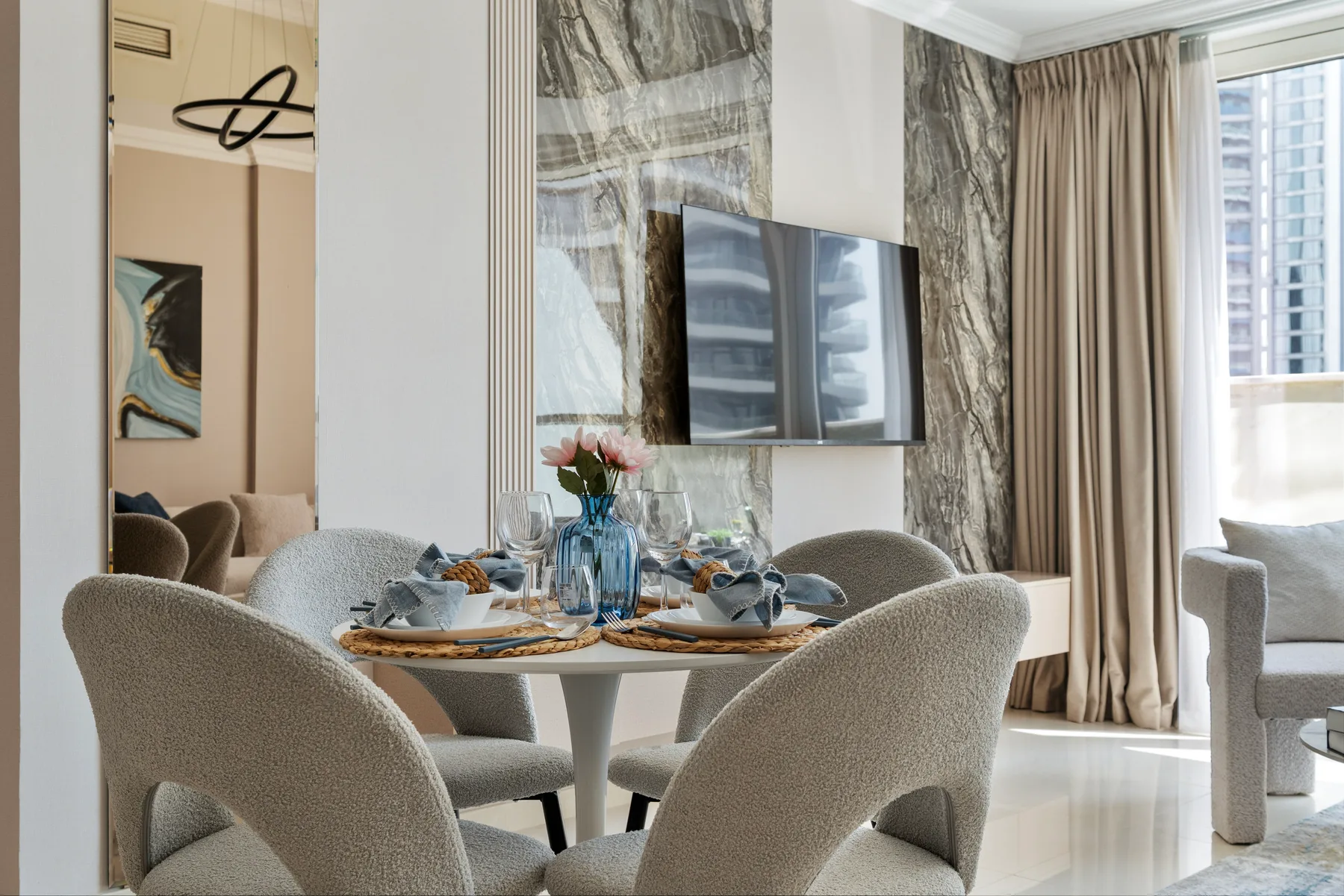 Un comedor con una mesa puesta y un televisor montado en la pared.