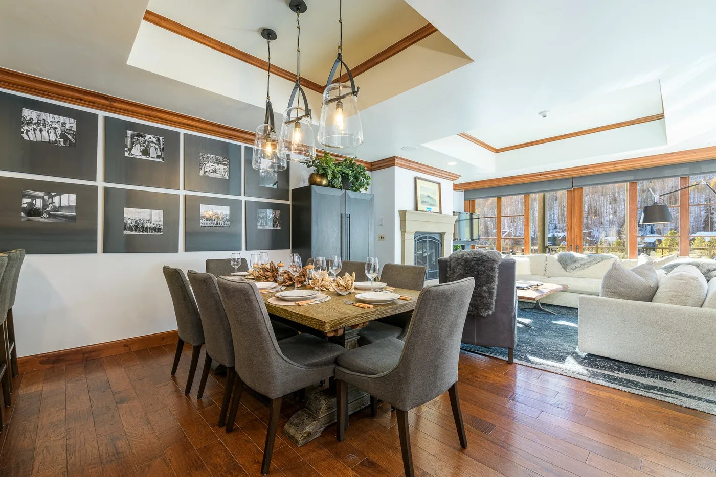 A dining area with a set table beside a bright living room.