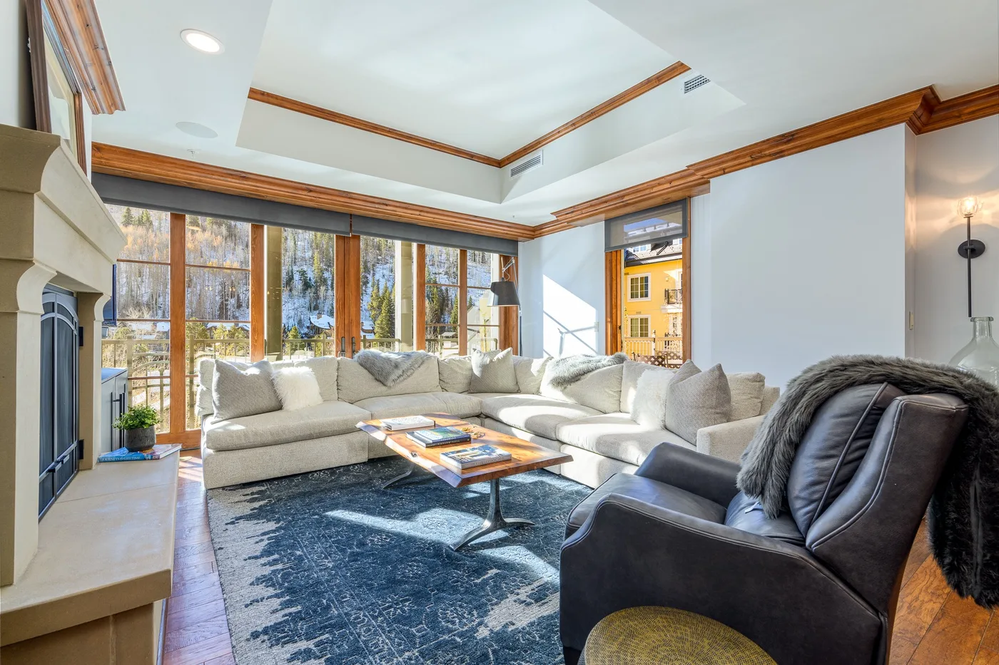 A bright living room with a large sectional seating area and tall windows.