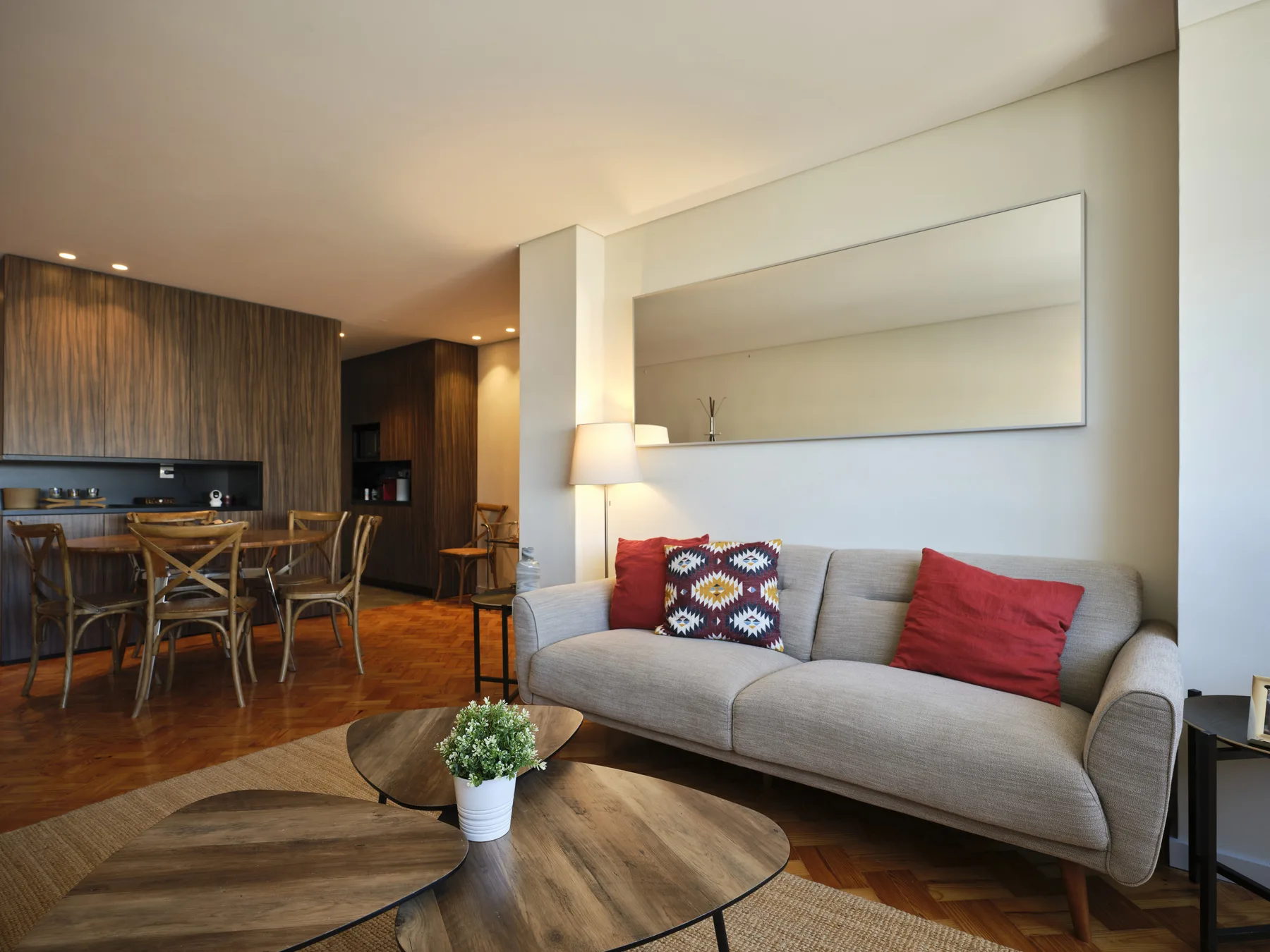 A living and dining area with a gray sofa and wooden table.