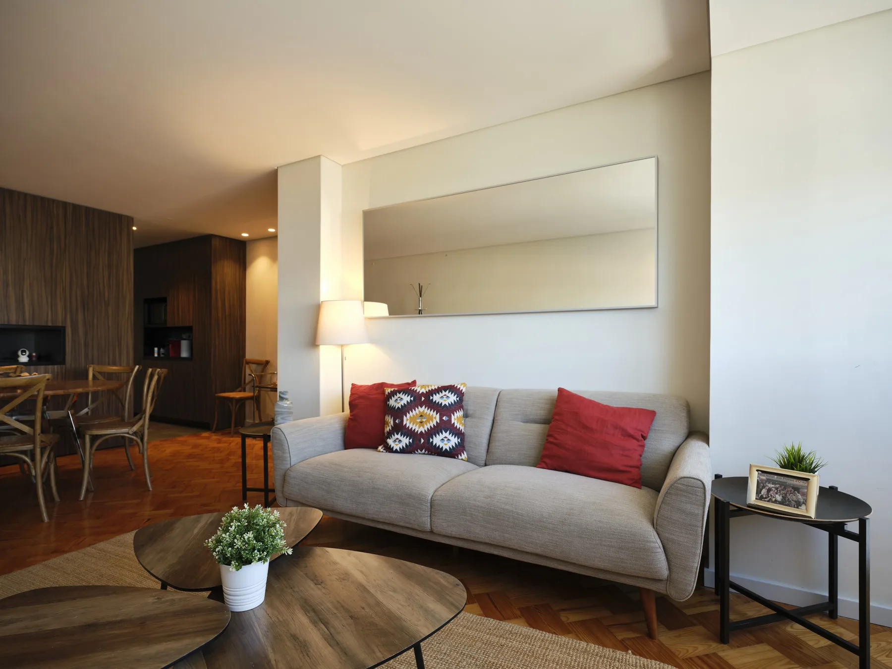 A living room with a gray sofa, coffee table, and dining area.