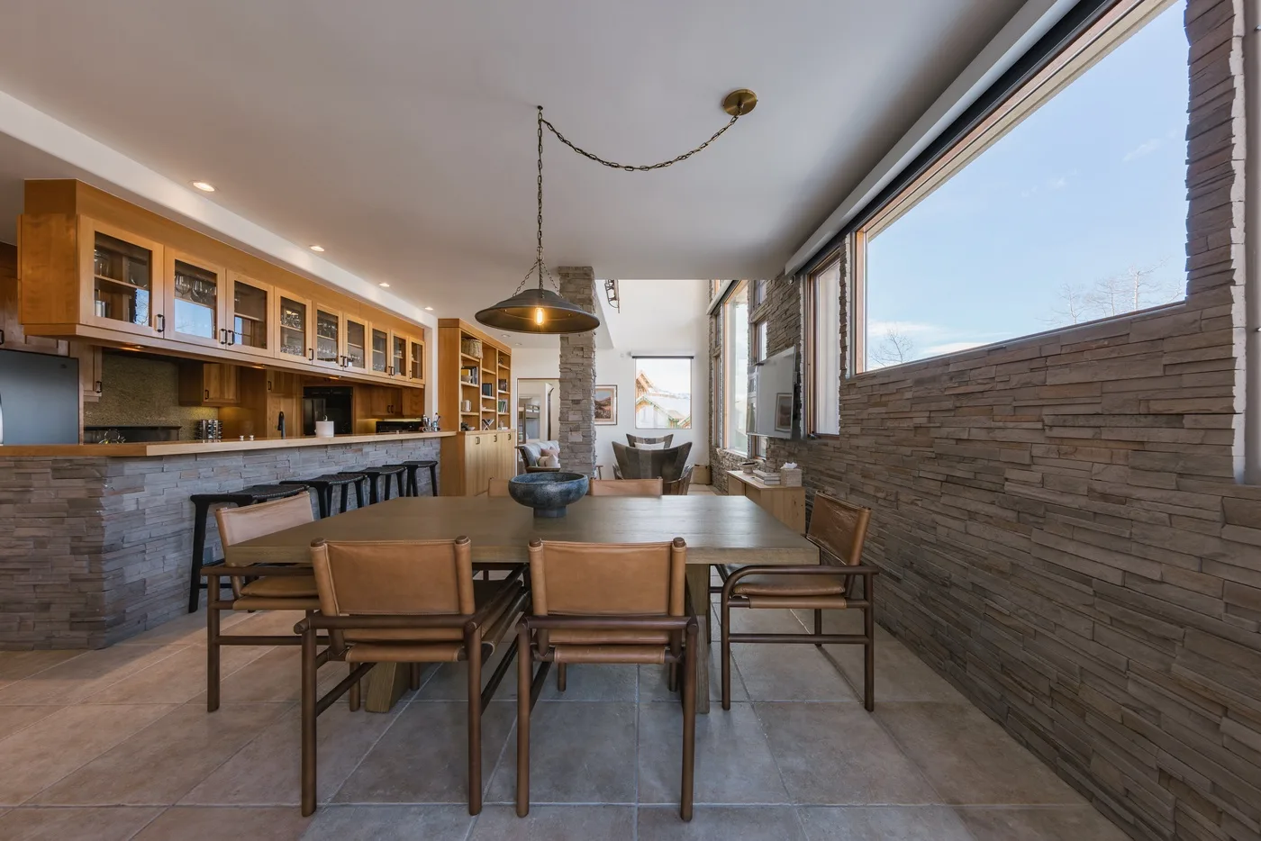 Comedor con una mesa larga y asientos de madera junto a una ventana amplia.