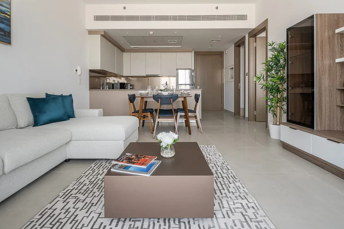 A bright living room opens onto a dining area and kitchen.