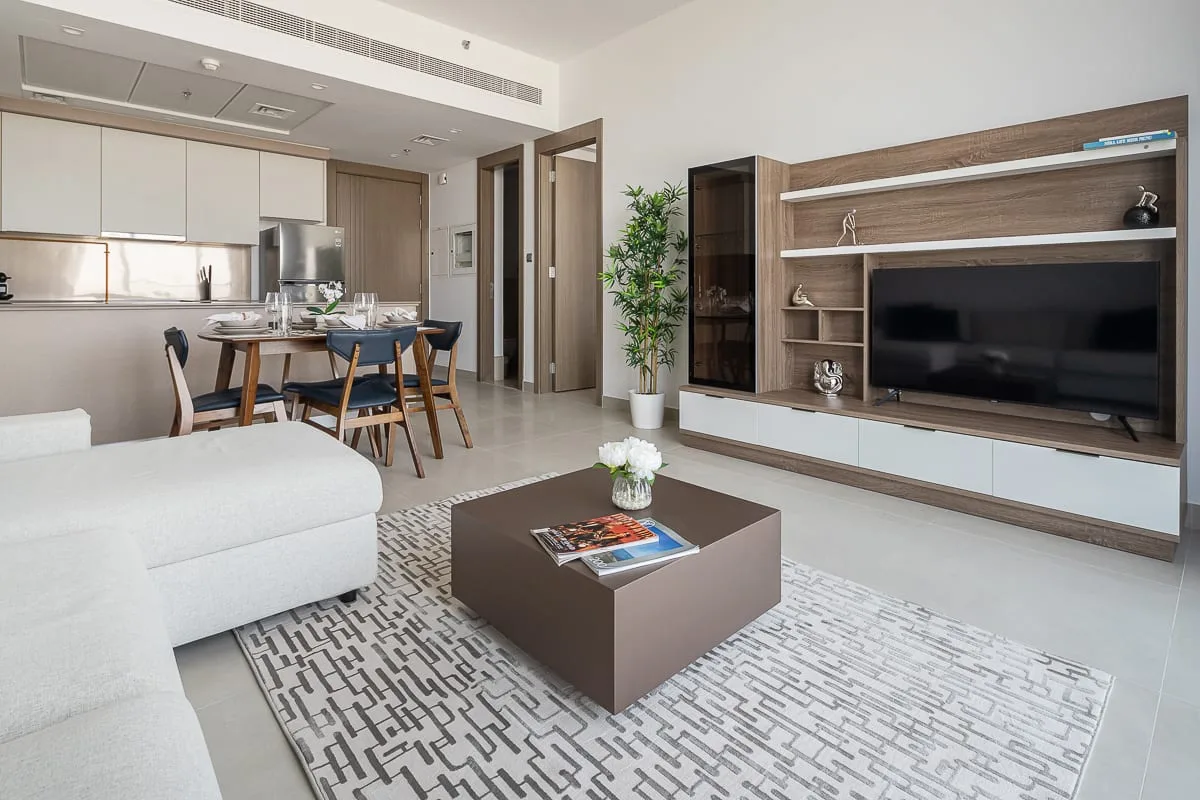 A bright living room with a television wall and dining area.