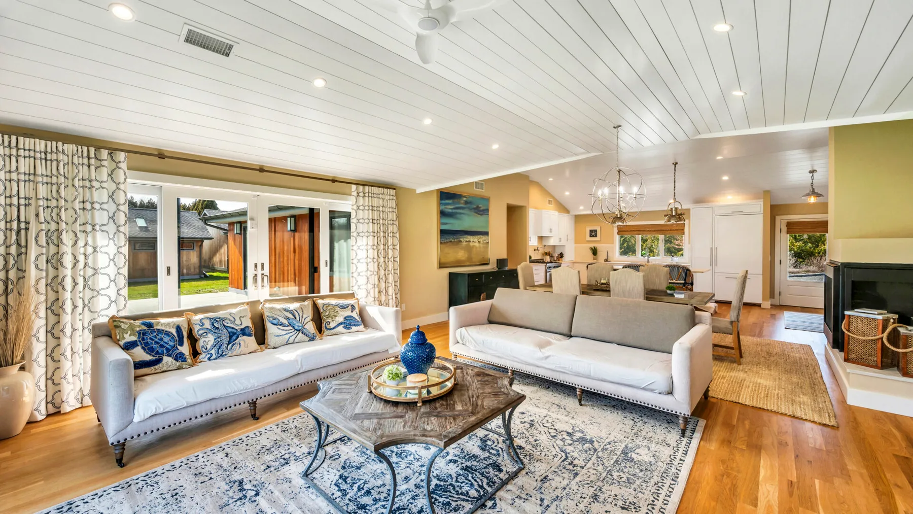 A bright living room with seating arranged around a glass coffee table.