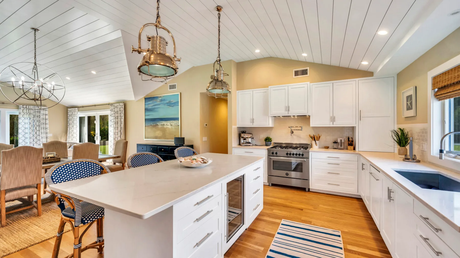 An open-plan kitchen and dining area with white cabinetry and a large island.