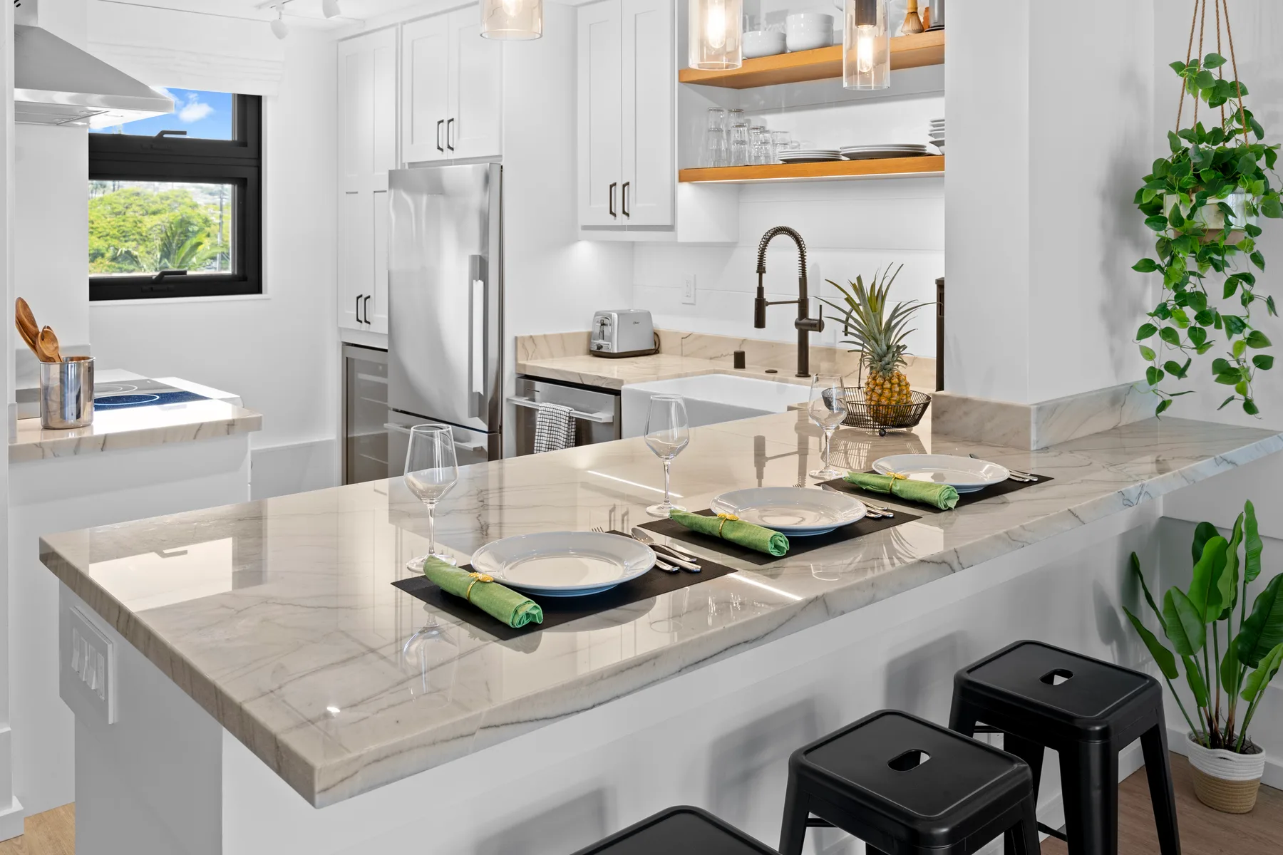 Una cocina moderna y luminosa con una gran isla puesta con platos y vasos.